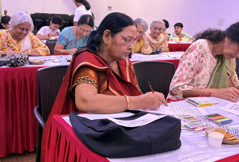 A room of older participants seated around tables, working on art activities together.