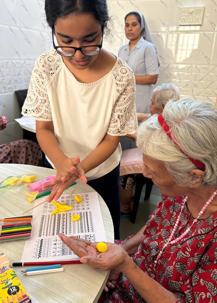 A volunteer helping an older participant choose colours at a workshop table.